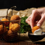 close up hand holding food croquette 1 1
