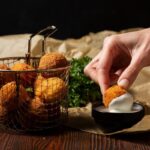 close up hand holding food croquette 1