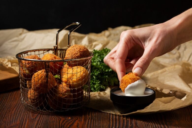 close up hand holding food croquette 1
